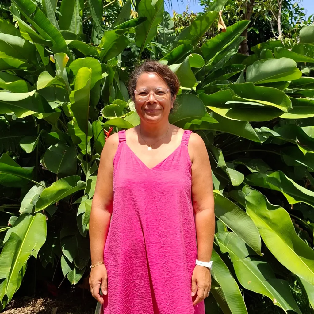 Sandrine TEYSSEDRE en robe fuchsia devant des plantes, gérante d’Agathe Formation Coworking à La Réunion